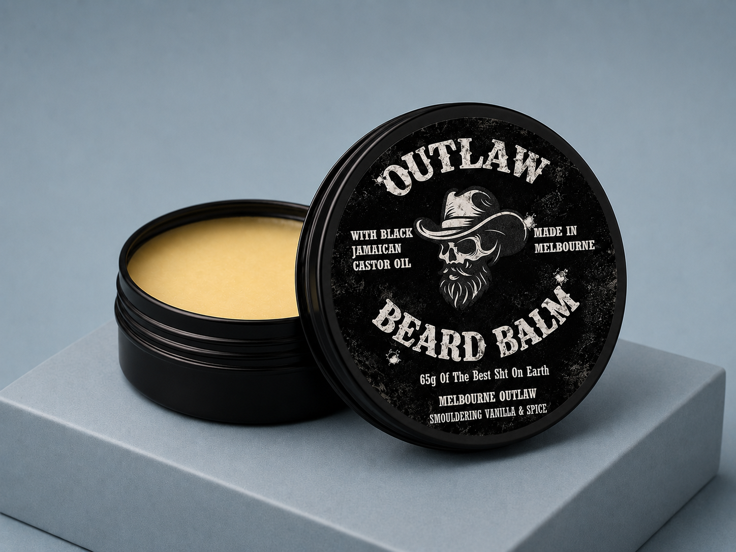 Outlaw Beard Balm container with lid open on a gray background
