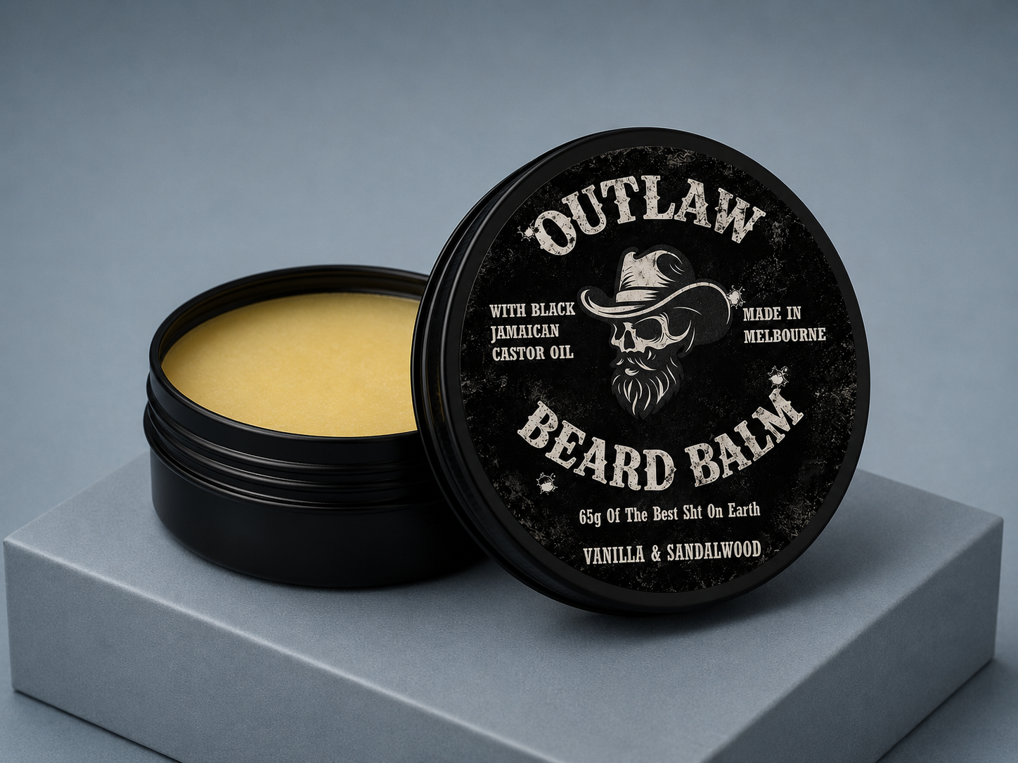 Beard balm container with lid open on a gray background